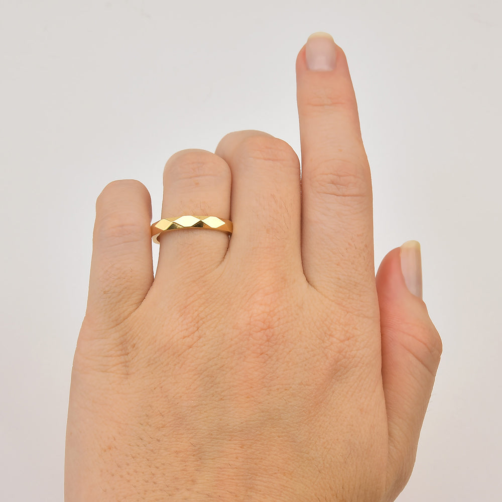 Aliança de ouro com facetas na mão